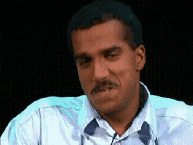a man with a mustache is wearing a blue shirt and tie
