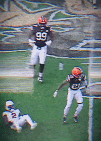 a football player wearing a number 99 jersey runs on the field