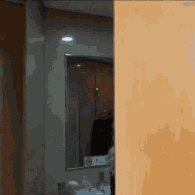 a bathroom with a mirror and a no smoking sign on the wall