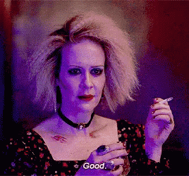 a woman is smoking a cigarette and saying " good "