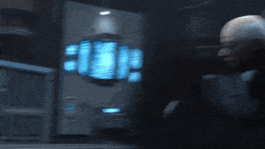 a blurry picture of a person standing in a dark room with a lot of blue lights .