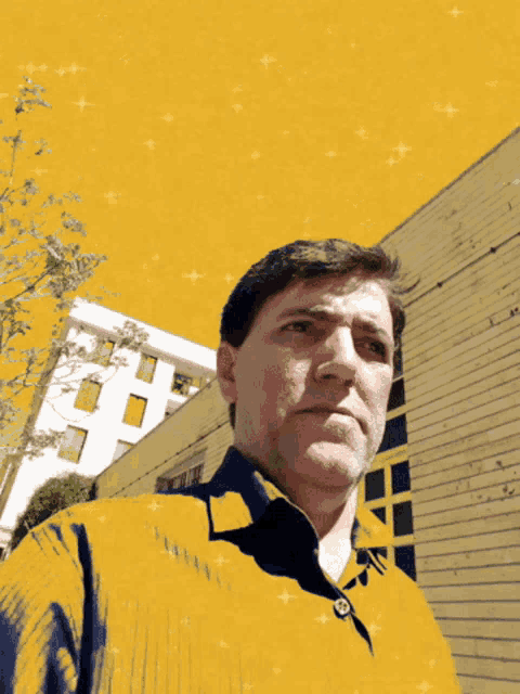 a man in a yellow shirt has a button on his shirt that says ' a ' on it