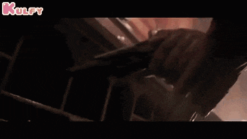 a close up of a person holding a gun with the words kulfy in the upper right corner