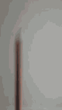 a blurred image of a pencil on a white wall