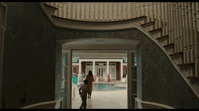 a man and woman are walking down a staircase towards a pool