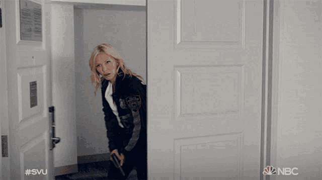 a woman standing in a doorway with the nbc logo on the bottom right