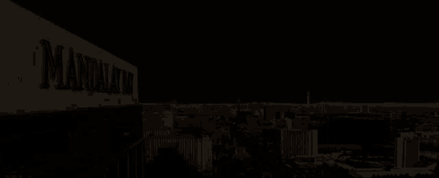 a sign that says ' mandalay bay ' on it is lit up at night