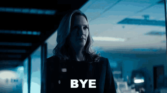 a woman is standing in a dark room with bye written on the bottom