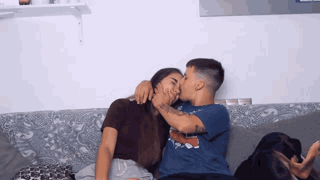 a man and a woman are kissing on a couch and the man is wearing a t-shirt that says i love you