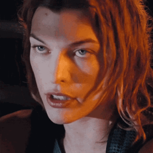 a close up of a woman 's face with blue eyes and red hair
