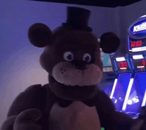 a teddy bear in a top hat is standing in front of a slot machine in an arcade .