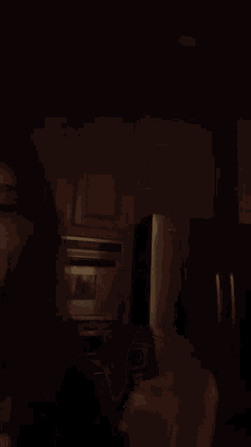 a person in a dark room holding a glass