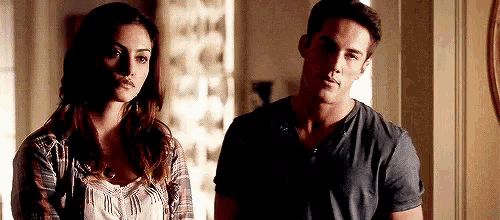 a man and a woman are standing next to each other and looking at each other .