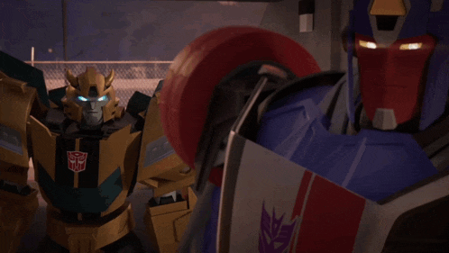two transformers are standing next to each other and one of them has the word transformers on it