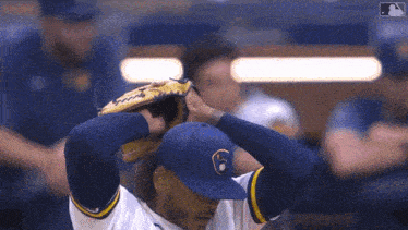 a baseball player in a milwaukee brewers uniform is adjusting his glove
