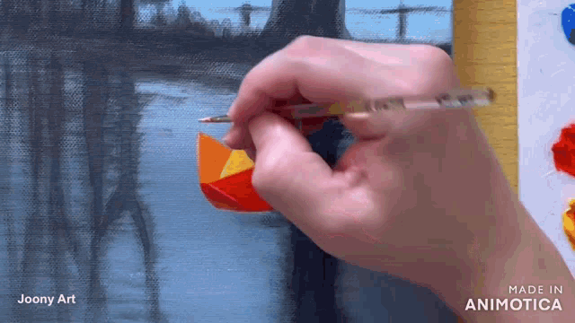 a hand is holding a brush in front of a painting with the words made in animatica on the bottom