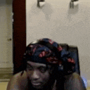 a man wearing a head scarf and headphones is sitting in a chair .
