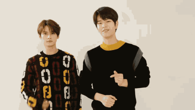 two young men are standing next to each other and one of them is wearing a sweater that says ' fendi ' on it
