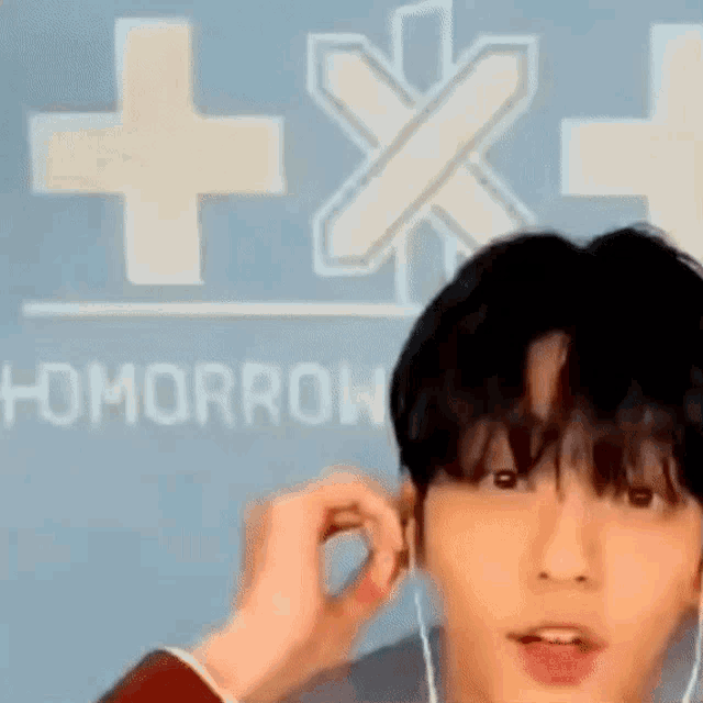 a close up of a person wearing earphones in front of a sign that says tomorrow .