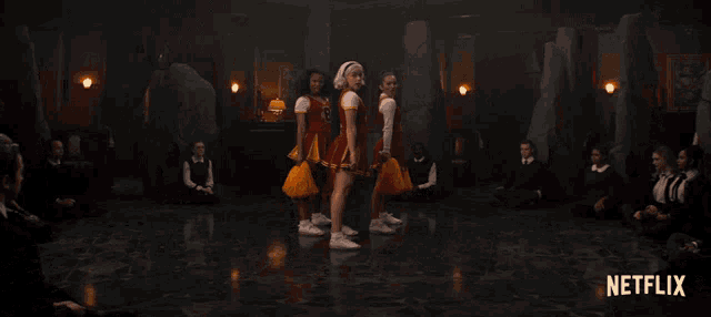three cheerleaders in red and yellow uniforms with the letter r on the front