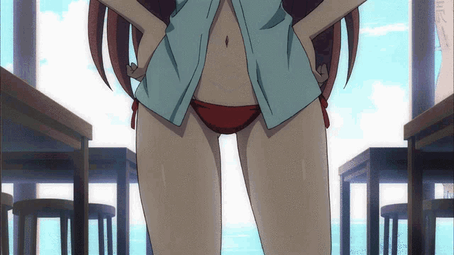 a girl in a blue shirt and red bikini is standing with her hands on her hips