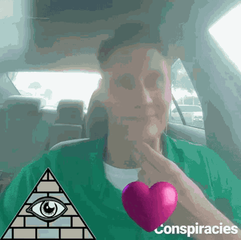a man in a green shirt is sitting in a car with a pyramid and an all seeing eye .
