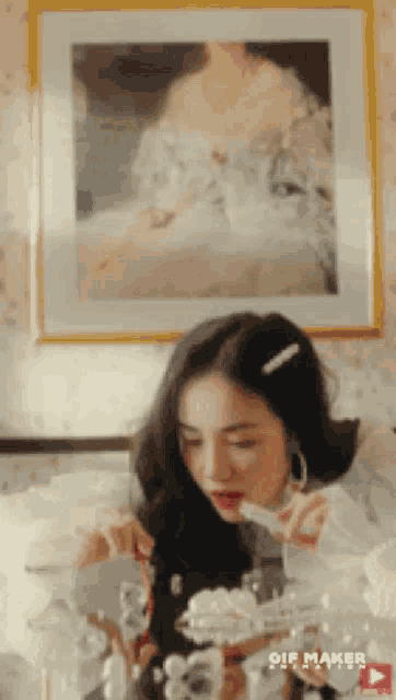 a woman is eating a dessert in front of a picture of a woman in a dress
