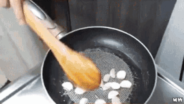 a wooden spoon is being used to stir food in a pan