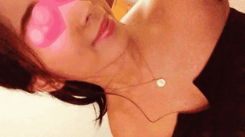 a woman is taking a selfie with a pink sticker on her eye