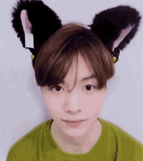 a young man is wearing a cat ear headband .