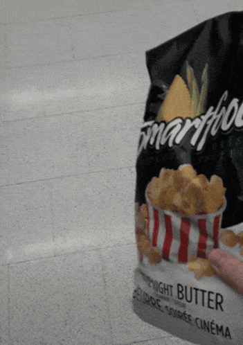 a person is holding a bag of popcorn that says midnight butter