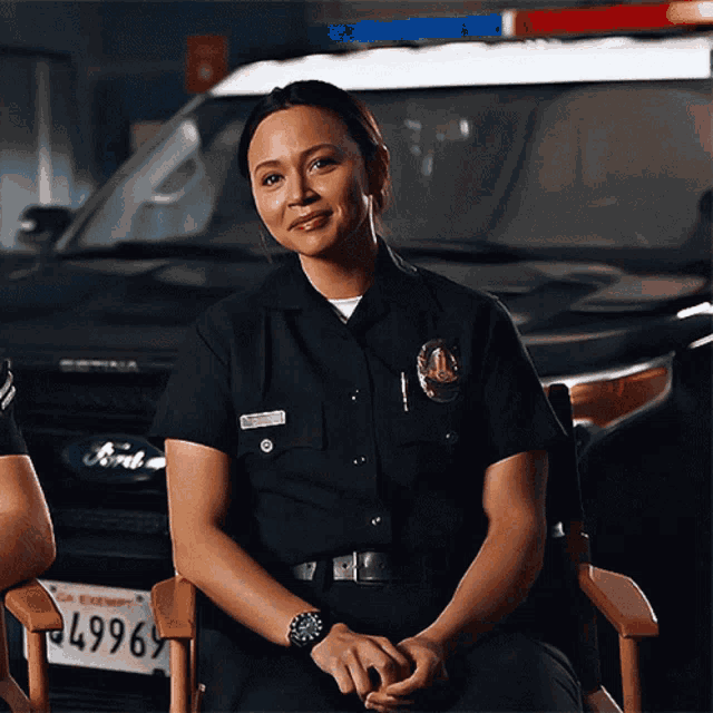 a female police officer sits in front of a ford car