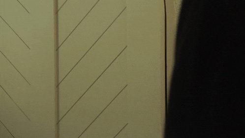 a woman peeking out from behind a door with her mouth taped