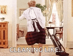 a woman is using a vacuum cleaner in a living room while dancing .