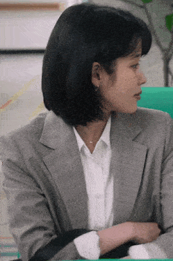 a woman wearing a grey suit and white shirt