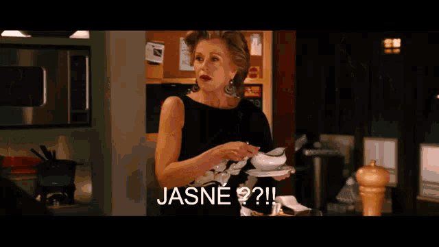 a woman in a black dress is standing in front of a microwave with the words jasne written on the screen