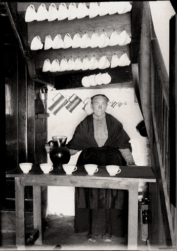 a black and white photo of a man sitting at a table