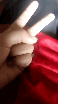 a person 's hand making a peace sign with their fingers