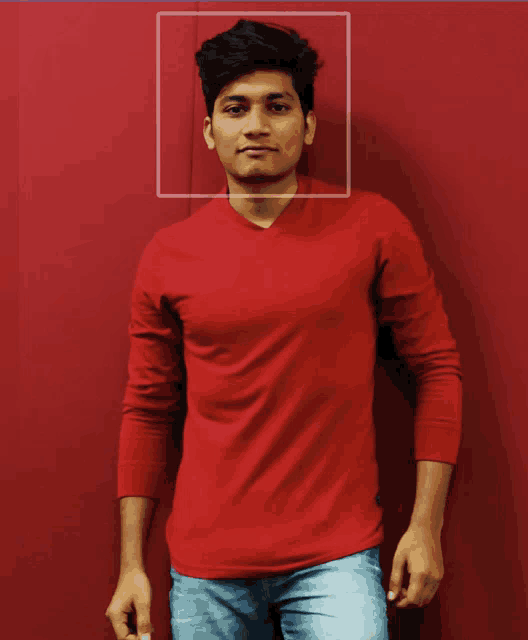 a man in a red shirt is standing in front of a red background