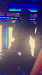 a blurry picture of a man dancing in a dark room with a blue light behind him