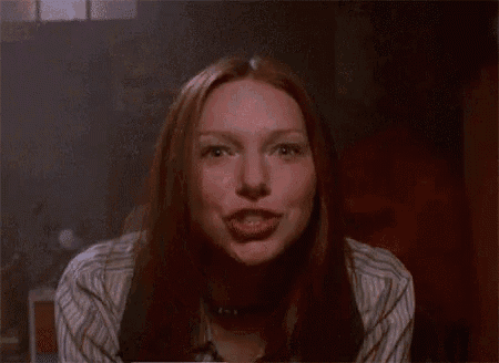 a woman with long hair is laughing with her mouth open .