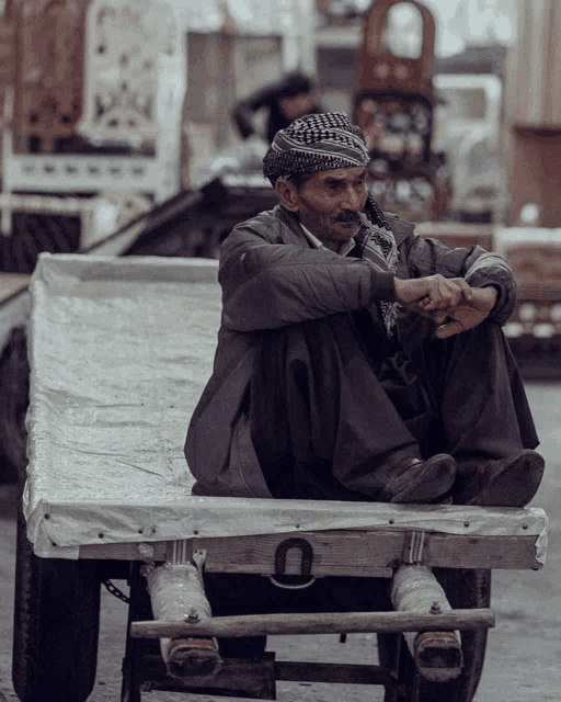 a man sits on the back of a cart with the letter u on it