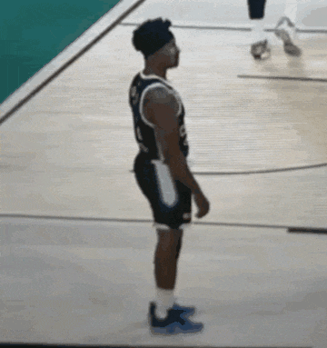 a man in a basketball uniform is standing on a basketball court