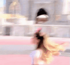 a woman in a white top and skirt is dancing on a pink surface