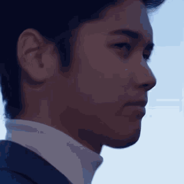 a close up of a man 's face with a blue background