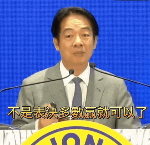 a man in a suit and tie stands at a podium with chinese writing