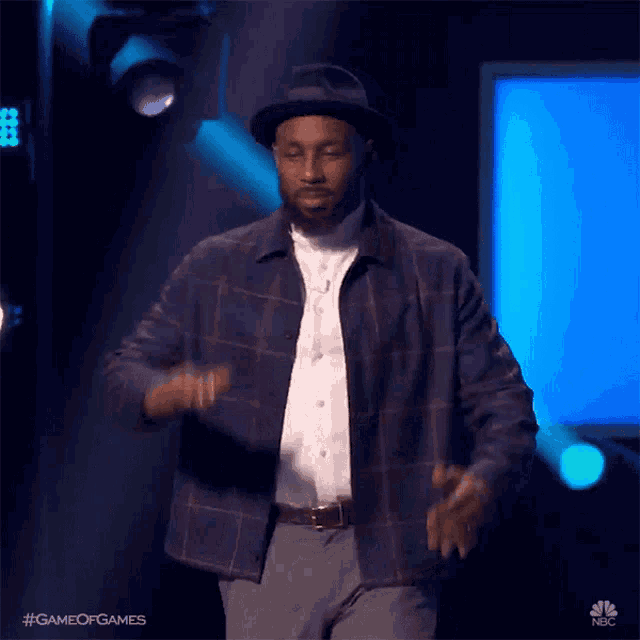 a man wearing a plaid shirt and a hat is dancing on a stage with the hashtag game of games