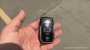 a person is holding a car key that has the numbers 818 on it