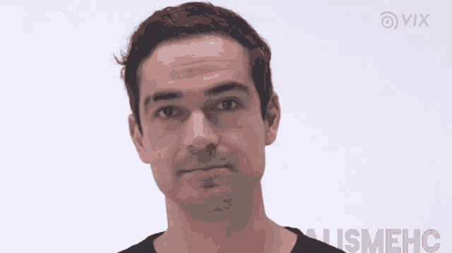a man in a black shirt is making a funny face in front of a white background with vix written on it
