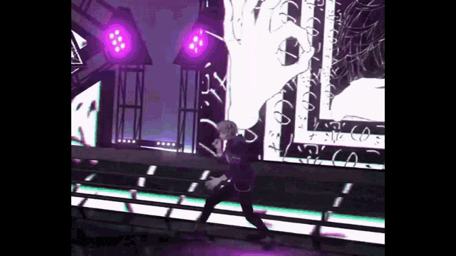 a man is dancing on a stage in front of a large screen with a hand on it